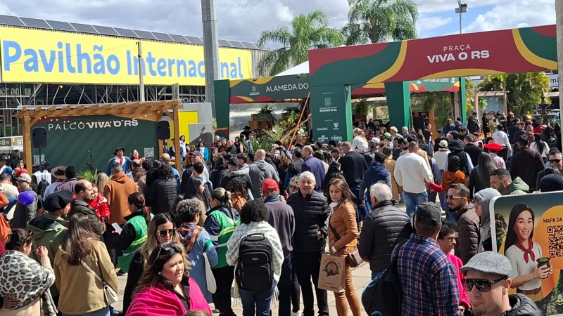 Foto mostra um corredor externo do parque lotado de pessoas circulando pela feira.
